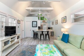 A compact living space with a television, kitchenette, dining area, and seating. - Get your ISLAND STLYE on! (Key West)