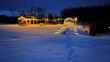 A snow-covered outdoor area with a gazebo and string lights.