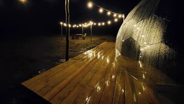 A tent with string lights on a wooden deck at night. - Dome in Wildlife

 (Martville)