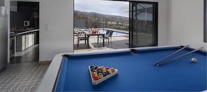 Enjoy leisure and entertainment in this well-equipped room with a pool table, dining area, and kitchen.