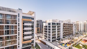 Un moderno complejo residencial con varias torres, balcones y un patio central con áreas verdes y de descanso.