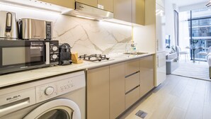 Una cocina moderna con electrodomésticos integrados, lavadora y comedor con vistas.