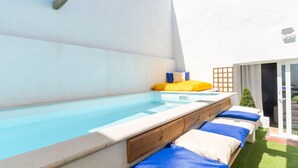 A swimming pool with a wooden deck and blue and beige lounge chairs. - Casa S o Jos in Carvalhal (Bombarral)
