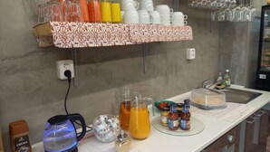 A breakfast bar with a variety of beverages, condiments, and a coffee maker. - Stará vinice (Velke Zernoseky)