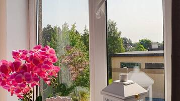 Una ventana con una orquídea en maceta, un marco decorativo con el texto "You are out" y un farol blanco.
