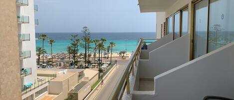 A balcony with a view of a beach and ocean.