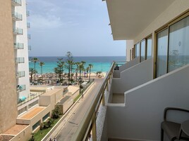 A balcony with a view of a beach and ocean.