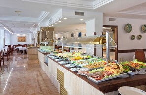 A buffet with various food options, a seating area with tables and chairs, and a ceiling with recessed lighting. - Biniamar (Sant Llorenc des Cardassar)