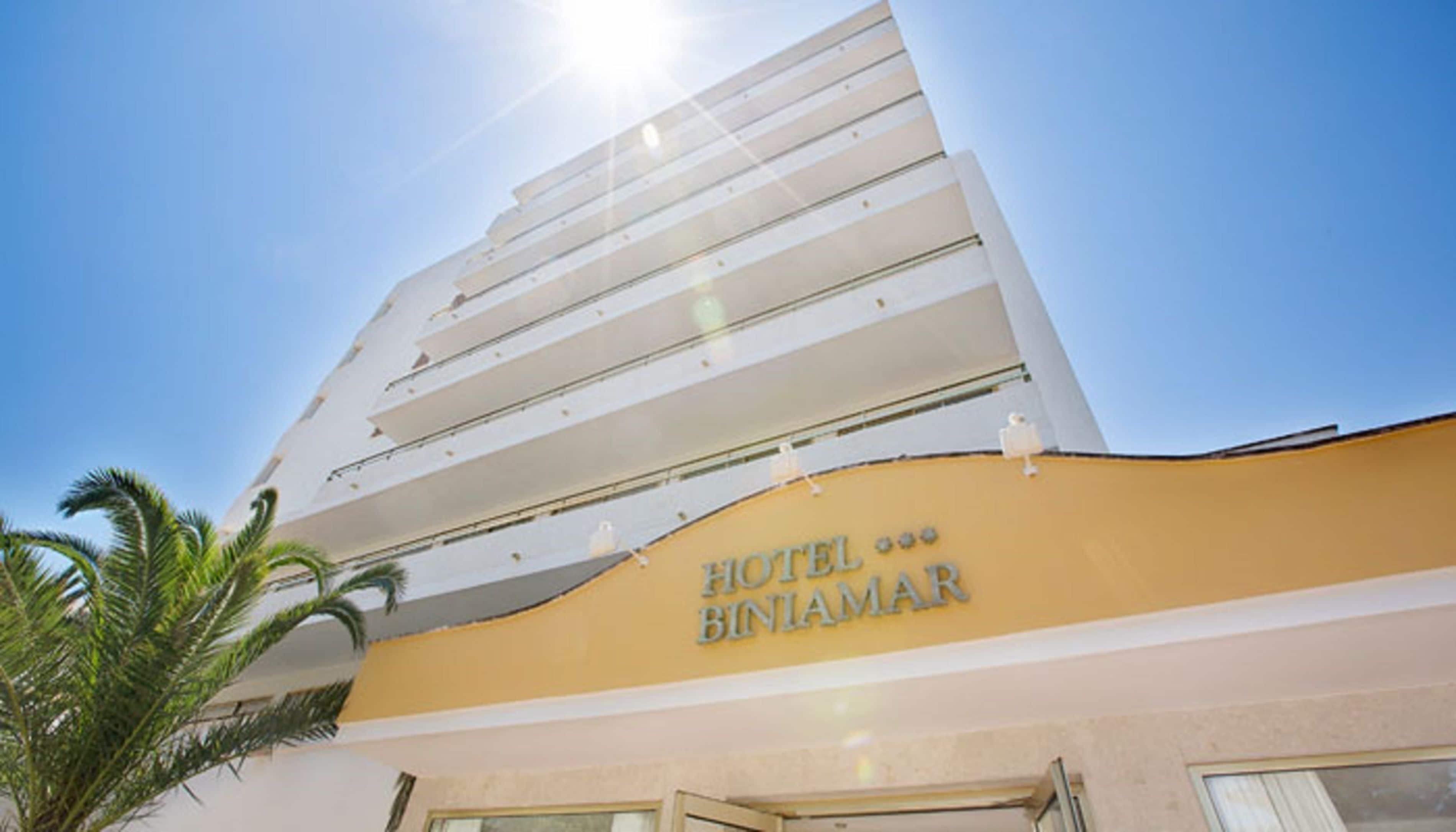 En hotellbyggnad med flera våningar, med en skylt som visar texten ”HOTEL BINIAMAR”.