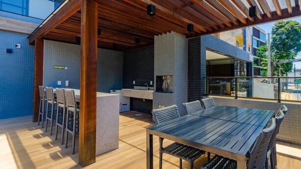 Un patio al aire libre con una pérgola de madera, una mesa de comedor y sillas.
