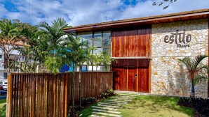 A modern building with a stone facade and a wooden door. - Apartment in Itacaré: Sun, Sea, and Comfort (Itacaré)