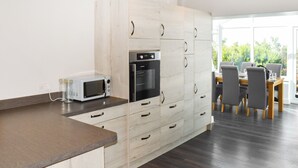 Eine moderne Küche mit integriertem Mikrowellenherd, Backofen und viel Stauraum in Schubladen.