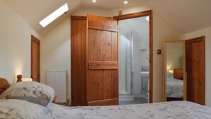 Ein Schlafzimmer mit einem großen Bett, einem Holzschrank und einem Dachfenster.