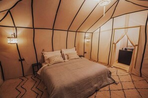 Simple, clean design surrounds a central bed, with ambient lighting and a patterned carpet.