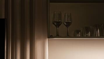 A kitchen area with a countertop holding wine glasses and a built-in stove.