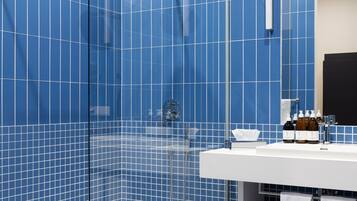 Klassieke studio | Badkamer | Een douche, een haardroger, handdoeken