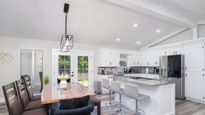 A modern kitchen with white cabinets, a granite countertop, and stainless steel appliances. - Modern House with King Suite! Relaxing Retreat!  (Springfield)