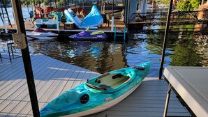 A kayak docked at a wooden pier with a covered area overhead. - Stay, Play, Getaway. Beautiful Lake Front Home-Large private dock  (Rocky Mount)