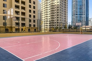An outdoor basketball court surrounded by high-rise buildings. - Beachside Haven Stylish 1 BHK in JBR Dubai (Dubai)