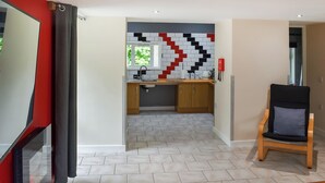 Eine moderne Küche mit gefliestem Spritzschutz, Holzschränken und einem Fenster.