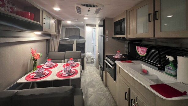 A compact kitchen with a dining area, equipped with a microwave, stove, and sink. - “NATURE IN THE CITY” (Orlando)
