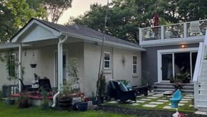 A house with a covered porch, a fenced yard, and a small deck. - The Lazy Susan (Charleston)