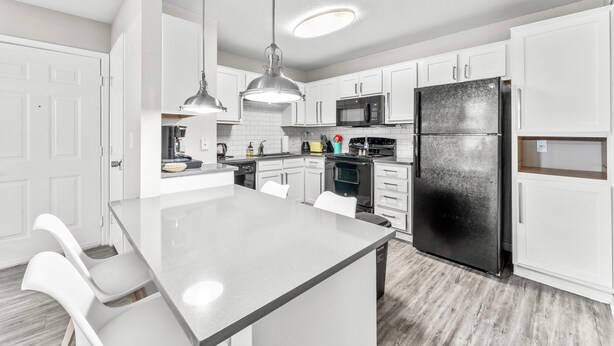A modern kitchen with white cabinetry, stainless steel appliances, and pendant lighting. - Central Quaint 1BR Close to UT Moody Center DT (Austin)