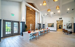 A spacious lobby with a long reception desk, multiple seating areas, and a large wooden accent wall. - Central Chic 2BR Close to UT Moody Center DT (Austin)