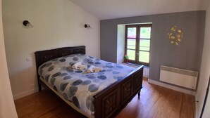 A bedroom with a bed, a window, a radiator, and a wall-mounted light fixture. - HOUSE 8-9 people LAVAUDIEU, most beautiful village in France. Pets allowed. (Lavadieu)