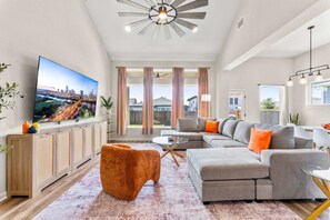 A modern living room with a flat-screen TV, a sectional sofa, and a coffee table.