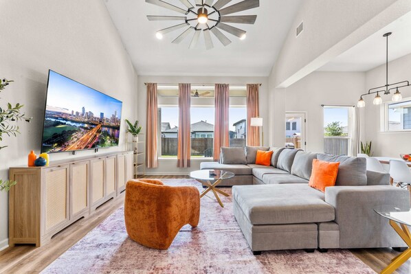 A modern living room with a flat-screen TV, a sectional sofa, and a coffee table.