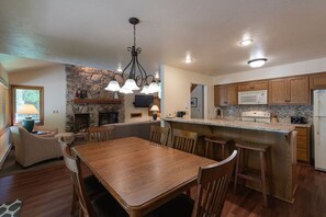 A spacious kitchen with a stone accent wall, wooden cabinetry, and a central island with bar stools.