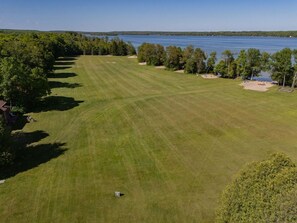 A golf course with a water body in the background.