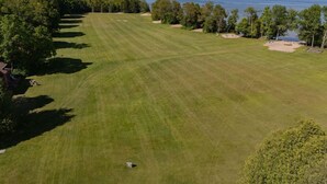 Un parcours de golf avec une étendue d’eau en arrière-plan.