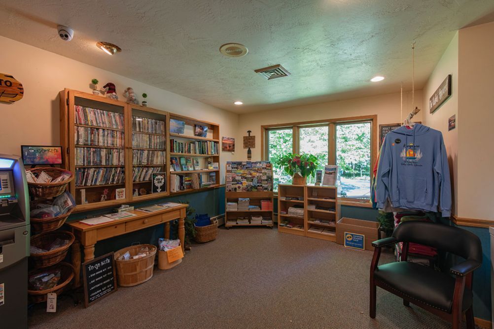 A cozy library with bookshelves, a computer, and a comfortable chair.