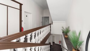 A staircase with white balusters and a brown handrail, leading to a landing with a door marked '14'. - Sona Design Rooms City Center (Bamberg)