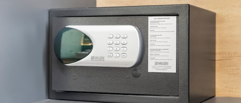 Una caja fuerte gris con teclado y las instrucciones en el lateral.
