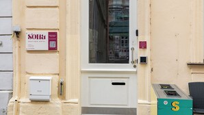 A hotel entrance with a white door, a signboard, and a green mailbox. - Sona Design Rooms City Center (Bamberg)