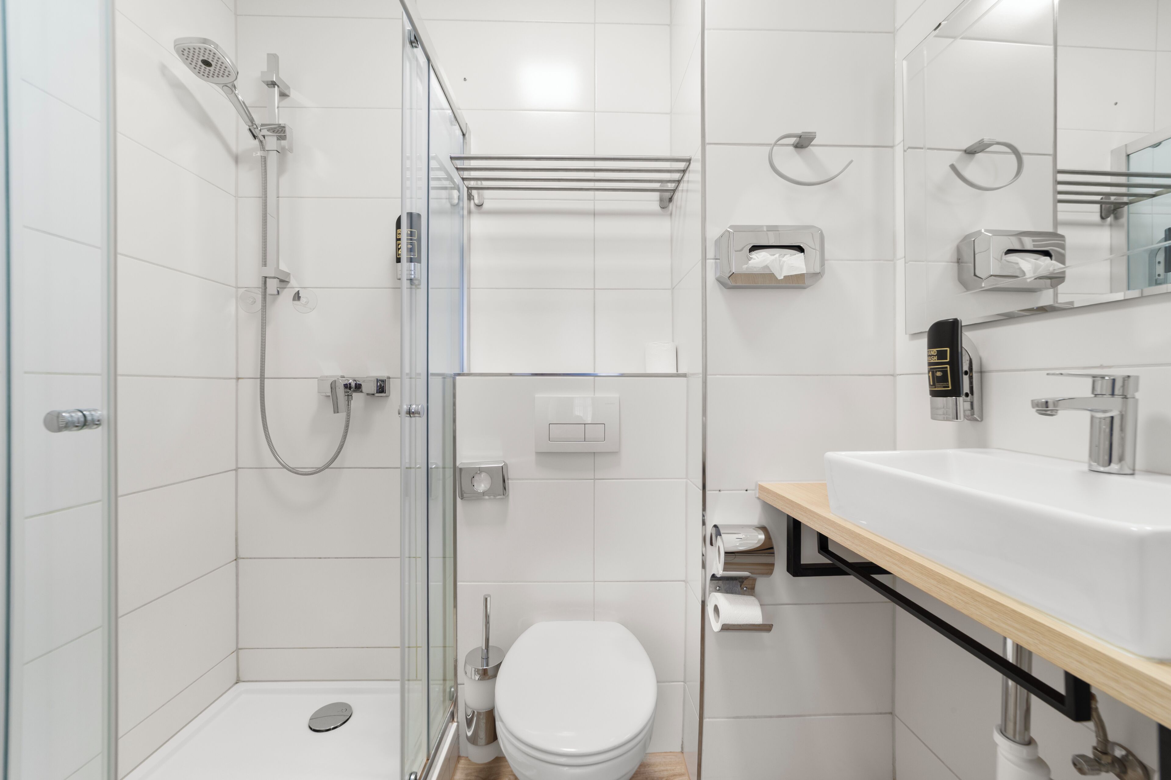 A modern bathroom with a shower, toilet, and sink.