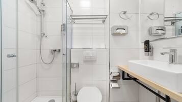 A modern bathroom with a shower, toilet, and sink.