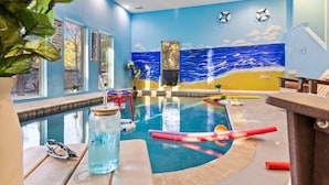 An indoor pool with a mural of the ocean, a basketball hoop, and a lifebuoy on the wall. - Elegant Elite Estate By Ghosal Luxury Lodging (Pigeon Forge)
