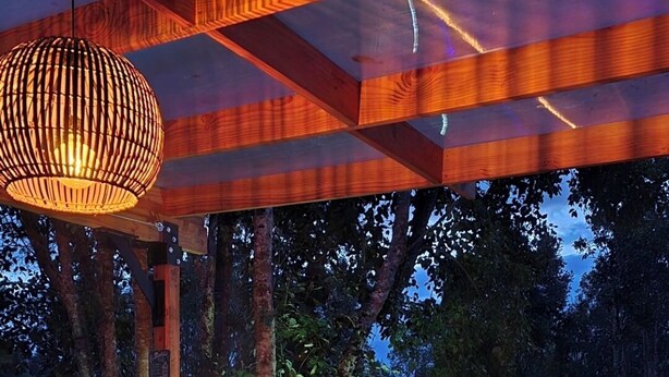 Un jacuzzi con terraza de madera y una lámpara colgante.
