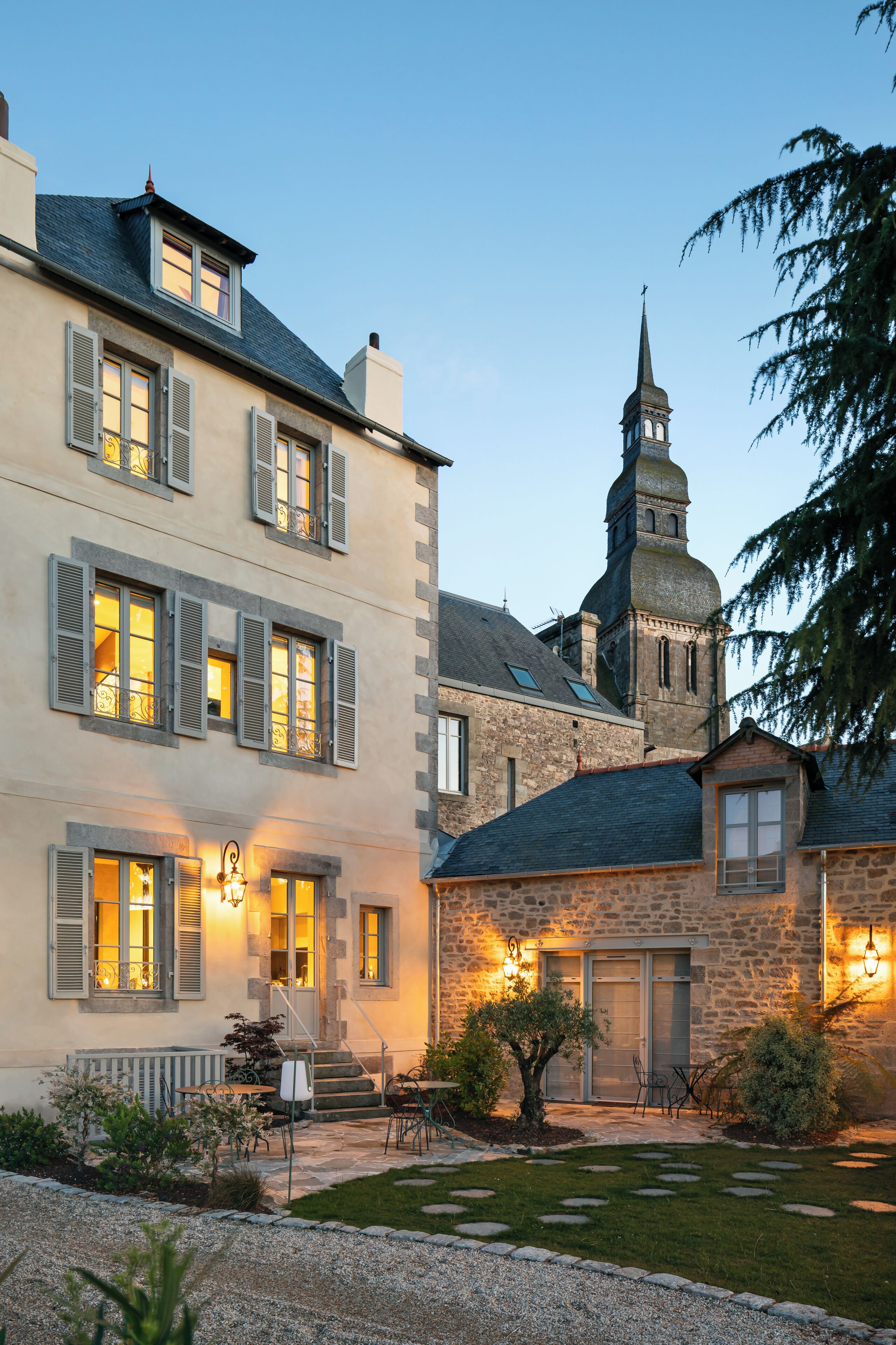 Ein historisches Gebäude mit einer steinernen Fassade, zahlreichen Fenstern mit Fensterläden und einem markanten Turm mit einer Spitze.