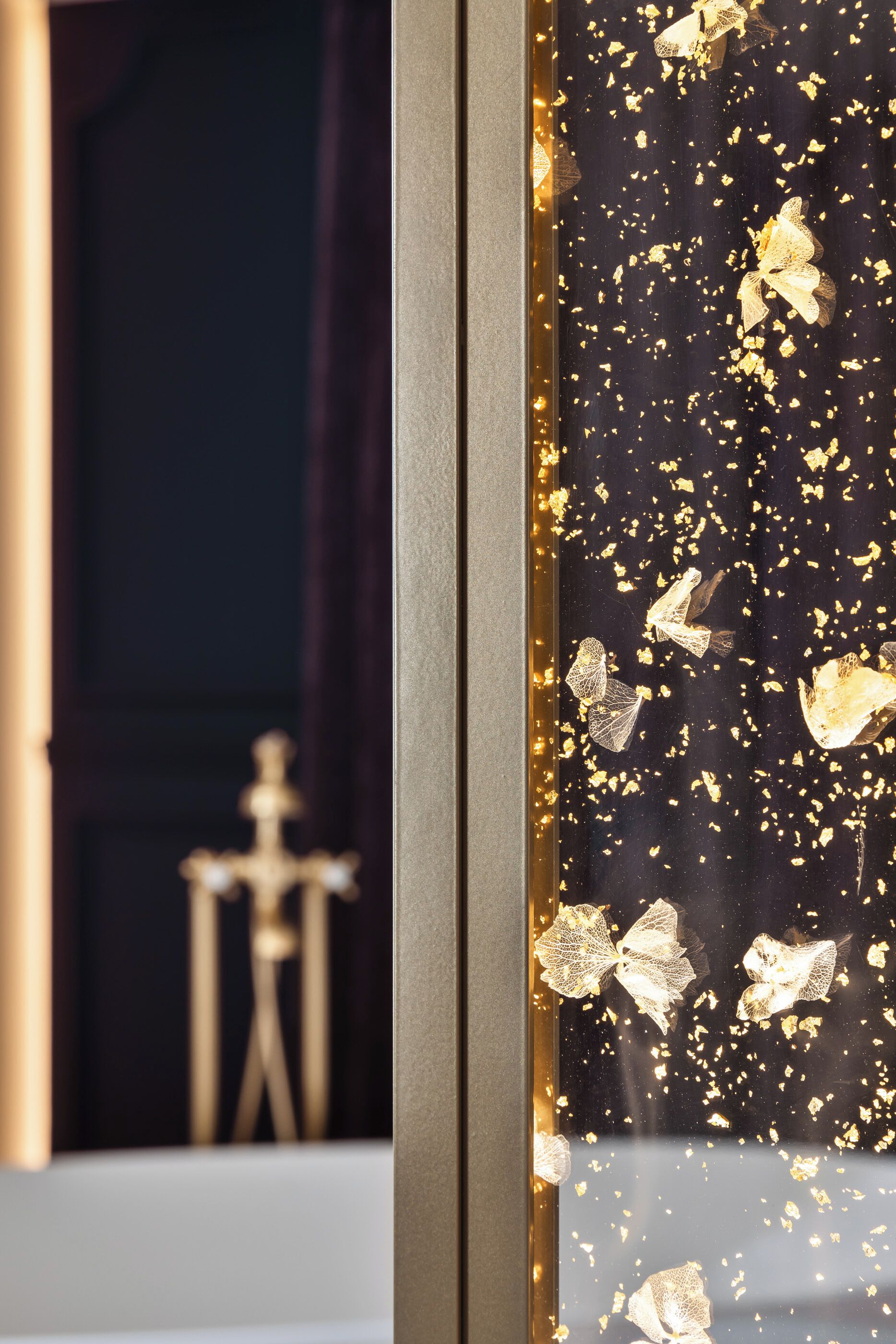 A close-up of a decorative glass panel with gold flakes and butterfly designs, part of a room's interior.