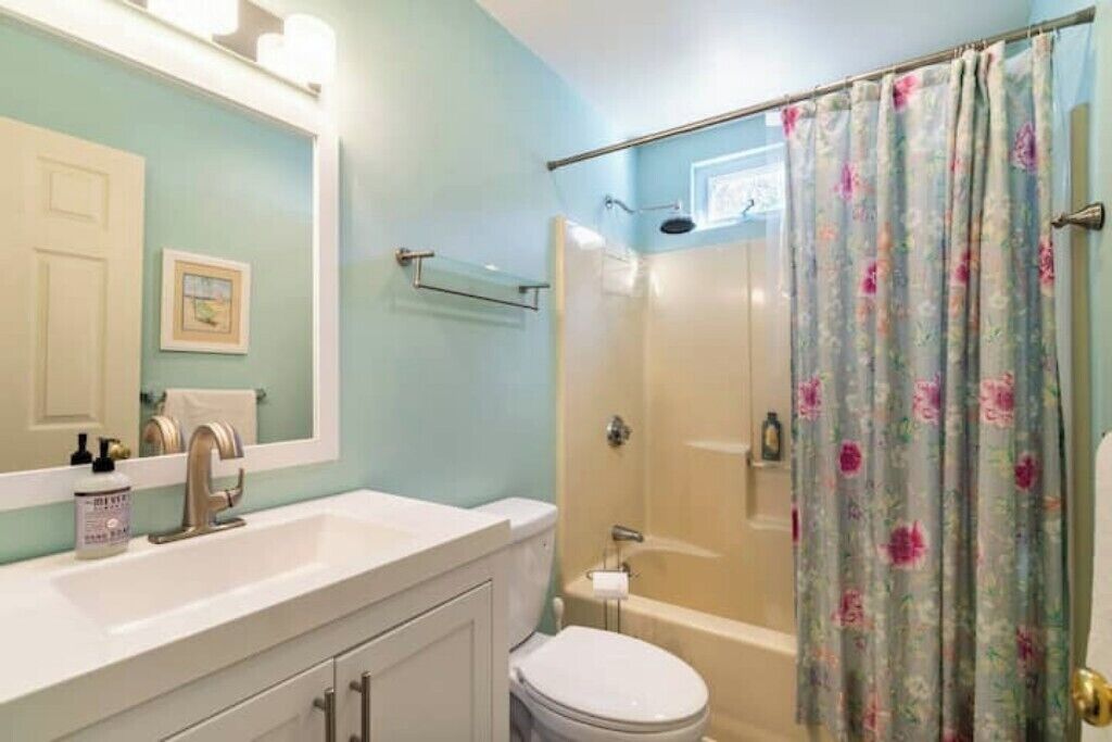 Un baño con ducha, inodoro y lavabo.