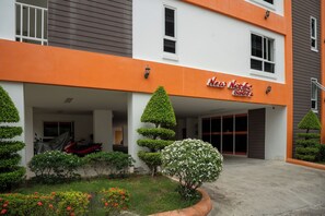 A hotel with a modern design, featuring a prominent orange facade and a sign that reads "New Nordic Suites."
