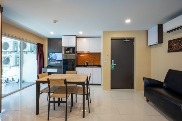 Un espacio habitable compacto con comedor, kitchenette y sofá.