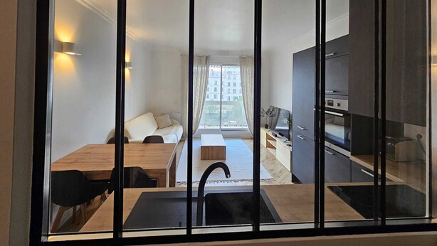 A modern apartment with a kitchen, dining area, and a living space with a sofa and a window overlooking the city. - Refait à Neuf: 5min des Champs-elysees, La Defense Arena, 20min la Tour Eiffel (Neuilly-sur-Seine)
