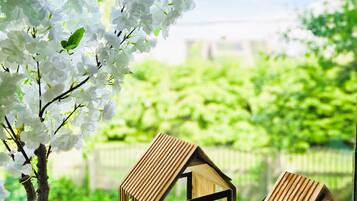 A potted tree with white blossoms and two wooden lanterns on a windowsill.