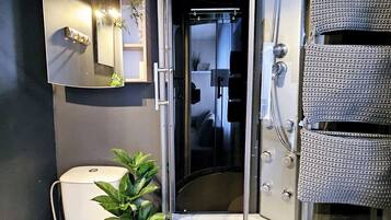 A modern bathroom with a toilet, a shower enclosure, and a bathtub.